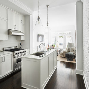 Traditional kitchen designs - Kitchen - traditional galley dark wood floor kitchen idea in DC Metro with shaker cabinets, white cabinets, white backsplash, subway tile backsplash and an island