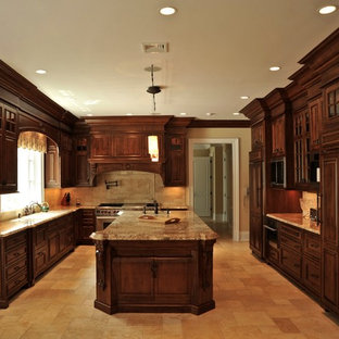 Traditional kitchen designs - Elegant kitchen photo in New York with raised-panel cabinets, brown cabinets and paneled appliances