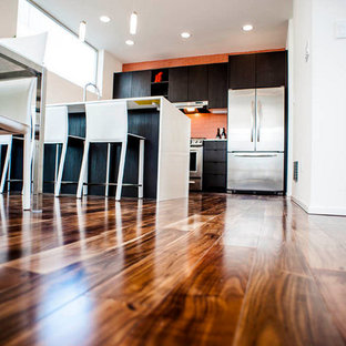 Immagine di una piccola cucina contemporanea con ante lisce, ante in legno bruno, top in superficie solida, paraspruzzi arancione, paraspruzzi con piastrelle a mosaico, elettrodomestici in acciaio inossidabile, pavimento marrone e pavimento in bambù