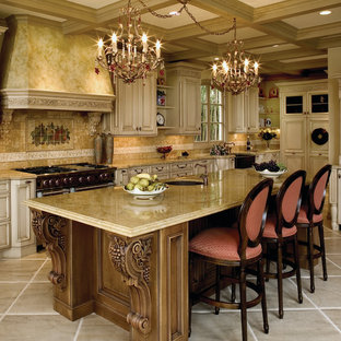 Photo of a large mediterranean u-shaped kitchen in Santa Barbara with a farmhouse sink, raised-panel cabinets, light wood cabinets, beige splashback, with island, limestone benchtops, limestone floors, beige floor and limestone splashback.