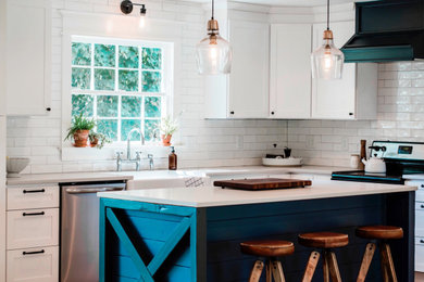 Kitchen - farmhouse light wood floor and beige floor kitchen idea in Other with a farmhouse sink, shaker cabinets, white cabinets, quartz countertops, white backsplash, ceramic backsplash, stainless steel appliances, an island and gray countertops