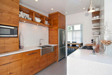 ミネアポリスにあるコンテンポラリースタイルのおしゃれなキッチン (フラットパネル扉のキャビネット、中間色木目調キャビネット、シルバーの調理設備) の写真