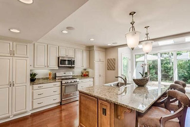 Eat-in kitchen - transitional single-wall medium tone wood floor eat-in kitchen idea in St Louis with a drop-in sink, raised-panel cabinets, stainless steel appliances and an island