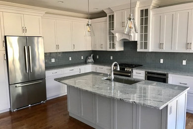 Example of a large classic galley dark wood floor eat-in kitchen design in Boston with a double-bowl sink, raised-panel cabinets, white cabinets, granite countertops, gray backsplash, stone tile backsplash, stainless steel appliances and no island