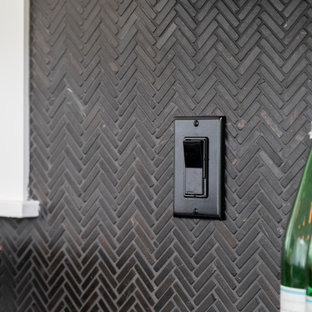 Contemporary eat-in kitchen ideas - Trendy single-wall eat-in kitchen photo in Seattle with black backsplash, mosaic tile backsplash, stainless steel appliances, an island and black countertops