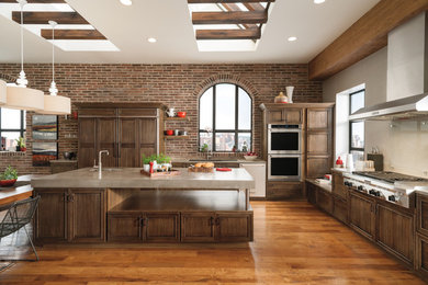 Open concept kitchen - large contemporary l-shaped medium tone wood floor open concept kitchen idea in Chicago with an undermount sink, recessed-panel cabinets, medium tone wood cabinets, concrete countertops, stone tile backsplash, stainless steel appliances and an island