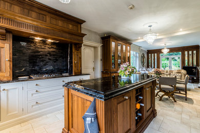 This is an example of a large classic u-shaped kitchen/diner in Cheshire with recessed-panel cabinets, dark wood cabinets, granite worktops, black splashback, black appliances and an island.
