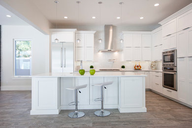 Photo of a large modern l-shaped kitchen/diner in Orlando with a submerged sink, shaker cabinets, white cabinets, quartz worktops, white splashback, glass tiled splashback, stainless steel appliances, ceramic flooring and an island.