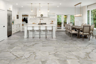 Elegant porcelain tile and gray floor kitchen photo in DC Metro with shaker cabinets, white cabinets, quartzite countertops, beige backsplash, stainless steel appliances, an island and white countertops