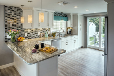 Inspiration for a small mid-century modern laminate floor and gray floor open concept kitchen remodel in Providence with an undermount sink, shaker cabinets, white cabinets, granite countertops, metallic backsplash, metal backsplash, stainless steel appliances and a peninsula