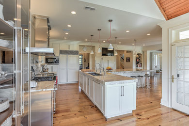 Large trendy l-shaped light wood floor eat-in kitchen photo in Philadelphia with an undermount sink, recessed-panel cabinets, white cabinets, quartzite countertops, gray backsplash, stone slab backsplash, stainless steel appliances and an island