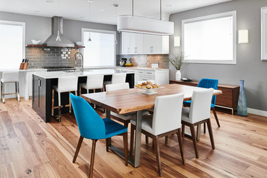 Mid-sized transitional l-shaped medium tone wood floor eat-in kitchen photo in Vancouver with shaker cabinets, quartz countertops, gray backsplash, an island, white cabinets, subway tile backsplash and white countertops