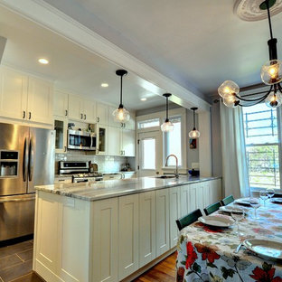 Photo of a mid-sized eclectic galley eat-in kitchen in DC Metro with an undermount sink, shaker cabinets, white cabinets, quartzite benchtops, white splashback, subway tile splashback, stainless steel appliances, porcelain floors and a peninsula.