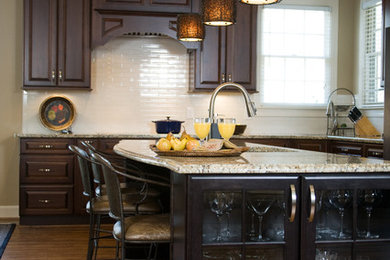 Imagen de cocina clásica abierta con puertas de armario de madera oscura y electrodomésticos de acero inoxidable