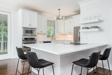 Huge minimalist single-wall dark wood floor and brown floor open concept kitchen photo in Charleston with an undermount sink, shaker cabinets, white cabinets, quartz countertops, white backsplash, porcelain backsplash, stainless steel appliances, an island and white countertops