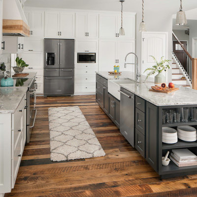 Example of a huge transitional galley medium tone wood floor and brown floor eat-in kitchen design in Columbus with a farmhouse sink, shaker cabinets, white cabinets, quartz countertops, white backsplash, ceramic backsplash, stainless steel appliances and an island