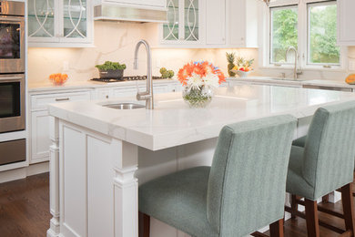 Eat-in kitchen - large transitional l-shaped medium tone wood floor and brown floor eat-in kitchen idea in New York with an undermount sink, shaker cabinets, white cabinets, quartz countertops, white backsplash, subway tile backsplash, stainless steel appliances, two islands and white countertops