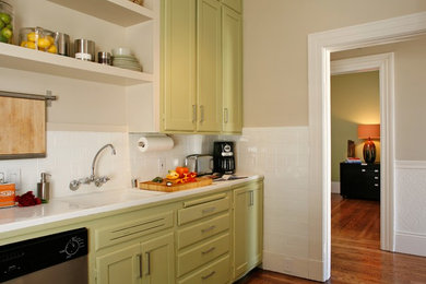 Small eclectic single-wall medium tone wood floor kitchen pantry photo in San Francisco with an undermount sink, flat-panel cabinets, green cabinets, white backsplash, ceramic backsplash, stainless steel appliances and no island