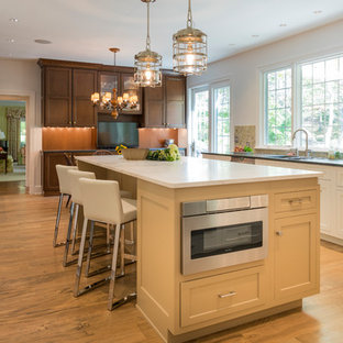 Immagine di una grande cucina chic con lavello sottopiano, ante in stile shaker, ante bianche, top in quarzite, paraspruzzi multicolore, paraspruzzi con piastrelle a mosaico, elettrodomestici in acciaio inossidabile, top bianco, pavimento in legno massello medio e pavimento marrone