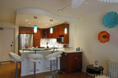 ハワイにある小さなコンテンポラリースタイルのおしゃれなキッチン (ガラスタイルのキッチンパネル、シルバーの調理設備、竹フローリング、アンダーカウンターシンク、青いキッチンパネル) の写真