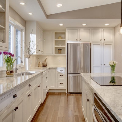 Kitchen - transitional l-shaped kitchen idea in Seattle with an undermount sink, shaker cabinets, white cabinets, stainless steel appliances, an island and window backsplash