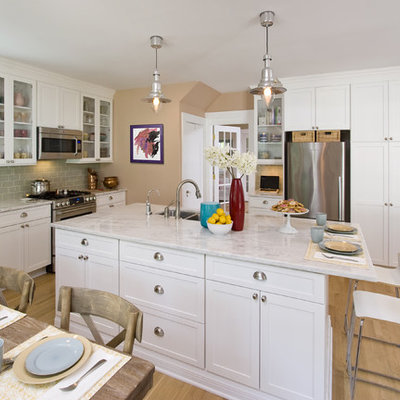 Open concept kitchen - mid-sized contemporary light wood floor open concept kitchen idea in New York with glass-front cabinets, stainless steel appliances, an undermount sink, white cabinets, marble countertops, ceramic backsplash, two islands and green backsplash