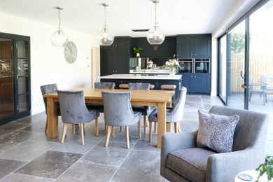 Design ideas for a medium sized contemporary open plan kitchen in Other with an integrated sink, shaker cabinets, blue cabinets, quartz worktops, metallic splashback, mirror splashback, integrated appliances, limestone flooring, an island, grey floors and white worktops.
