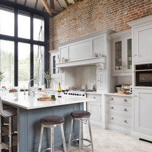 This is an example of a large traditional l-shaped open plan kitchen in Essex with a built-in sink, shaker cabinets, grey cabinets, quartz worktops, white splashback, stainless steel appliances, limestone flooring, an island, beige floors and white worktops.
