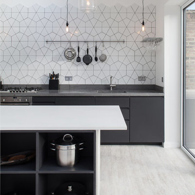 Inspiration for a contemporary kitchen remodel in London with an undermount sink, flat-panel cabinets, black cabinets, white backsplash and an island