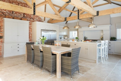 Inspiration for a large farmhouse kitchen/diner in Other with a built-in sink, shaker cabinets, white cabinets, quartz worktops, white splashback, marble splashback, stainless steel appliances, travertine flooring, an island and beige floors.