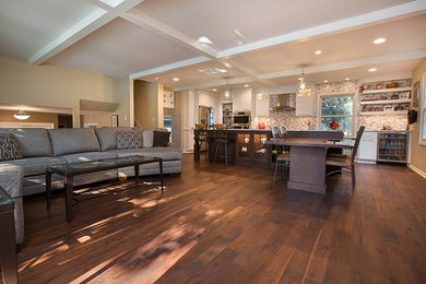 Example of a mid-sized trendy l-shaped dark wood floor and brown floor kitchen design in Other with a farmhouse sink, flat-panel cabinets, white cabinets, multicolored backsplash, mosaic tile backsplash, stainless steel appliances and an island