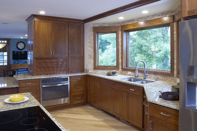 Example of a transitional light wood floor kitchen design in Milwaukee with an undermount sink, recessed-panel cabinets, medium tone wood cabinets, granite countertops, beige backsplash, ceramic backsplash, stainless steel appliances and an island