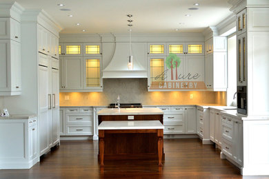 Ejemplo de cocina clásica grande con armarios con paneles lisos, puertas de armario blancas, encimera de mármol y una isla