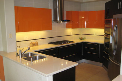Esempio di una piccola cucina design con lavello sottopiano, ante lisce, ante arancioni, top in superficie solida, paraspruzzi beige, paraspruzzi con piastrelle in ceramica, elettrodomestici in acciaio inossidabile e pavimento in gres porcellanato