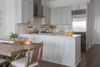 Inspiration for a small transitional l-shaped medium tone wood floor and brown floor eat-in kitchen remodel in Jacksonville with an undermount sink, shaker cabinets, white cabinets, quartz countertops, white backsplash, porcelain backsplash, stainless steel appliances, an island and beige countertops