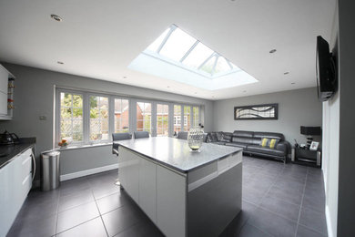 Contemporary kitchen in West Midlands with flat-panel cabinets, white cabinets and an island.