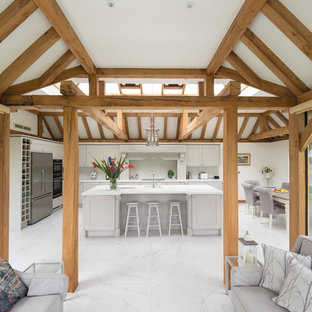 Large rustic l-shaped kitchen in West Midlands with white floors, recessed-panel cabinets, grey cabinets, white splashback, stainless steel appliances, an island and white worktops.