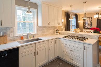 Example of a mid-sized transitional u-shaped ceramic tile and gray floor eat-in kitchen design in New York with an undermount sink, recessed-panel cabinets, white cabinets, quartz countertops, gray backsplash, stone tile backsplash, black appliances and a peninsula