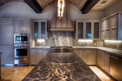 Open concept kitchen - large mediterranean l-shaped travertine floor and brown floor open concept kitchen idea in Austin with a farmhouse sink, recessed-panel cabinets, gray cabinets, marble countertops, gray backsplash, stone slab backsplash, paneled appliances and no island