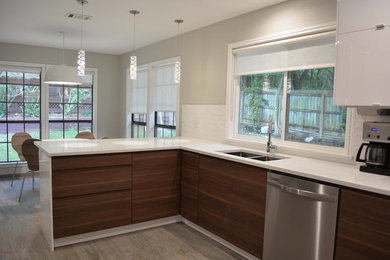 Example of a mid-sized minimalist u-shaped porcelain tile and gray floor eat-in kitchen design in Austin with an undermount sink, flat-panel cabinets, medium tone wood cabinets, quartzite countertops, white backsplash, ceramic backsplash, stainless steel appliances, a peninsula and white countertops