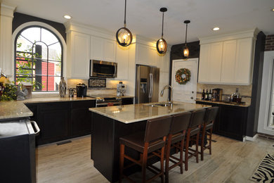 Example of a mid-sized eclectic u-shaped porcelain tile eat-in kitchen design in Other with an undermount sink, shaker cabinets, white cabinets, granite countertops, beige backsplash, stone tile backsplash, stainless steel appliances and an island