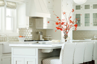 Example of a large classic u-shaped dark wood floor and brown floor kitchen design in Portland with a farmhouse sink, shaker cabinets, white cabinets, marble countertops, gray backsplash, subway tile backsplash, stainless steel appliances and an island