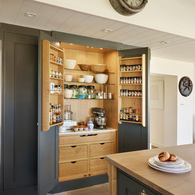 Inspiration for a large transitional kitchen pantry remodel in Essex with gray cabinets, wood countertops and an island