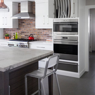 Mid-sized transitional eat-in kitchen photos - Mid-sized transitional l-shaped porcelain tile and gray floor eat-in kitchen photo in New York with a single-bowl sink, flat-panel cabinets, white cabinets, quartzite countertops, brown backsplash, brick backsplash, stainless steel appliances and an island