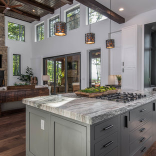 Large rustic open concept kitchen designs - Example of a large mountain style dark wood floor and brown floor open concept kitchen design in Other with shaker cabinets, white cabinets, granite countertops, white backsplash, window backsplash, stainless steel appliances, an island and black countertops