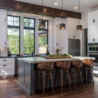 Large rustic eat-in kitchen photos - Inspiration for a large rustic l-shaped dark wood floor and brown floor eat-in kitchen remodel in Other with an undermount sink, shaker cabinets, white cabinets, granite countertops, white backsplash, window backsplash, stainless steel appliances, an island and black countertops