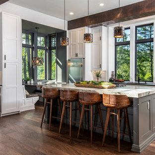Large rustic eat-in kitchen designs - Inspiration for a large rustic l-shaped dark wood floor and brown floor eat-in kitchen remodel in Other with shaker cabinets, white cabinets, window backsplash, stainless steel appliances, an island, black countertops, an undermount sink, granite countertops and white backsplash