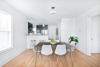 Small minimalist u-shaped light wood floor and brown floor eat-in kitchen photo in New York with an undermount sink, flat-panel cabinets, dark wood cabinets, quartz countertops, white backsplash, ceramic backsplash, stainless steel appliances, a peninsula and gray countertops