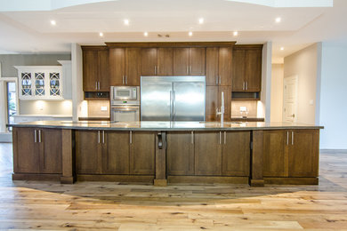 Diseño de cocina clásica renovada grande con fregadero bajoencimera, armarios estilo shaker, puertas de armario de madera en tonos medios, electrodomésticos blancos y una isla