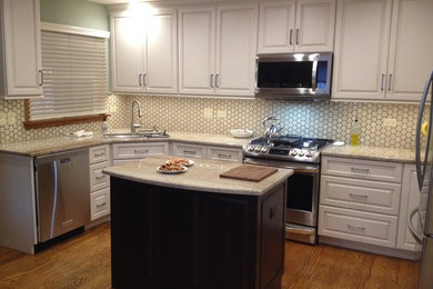 Mid-sized transitional u-shaped medium tone wood floor kitchen photo in Chicago with a single-bowl sink, raised-panel cabinets, beige cabinets, stainless steel appliances and an island